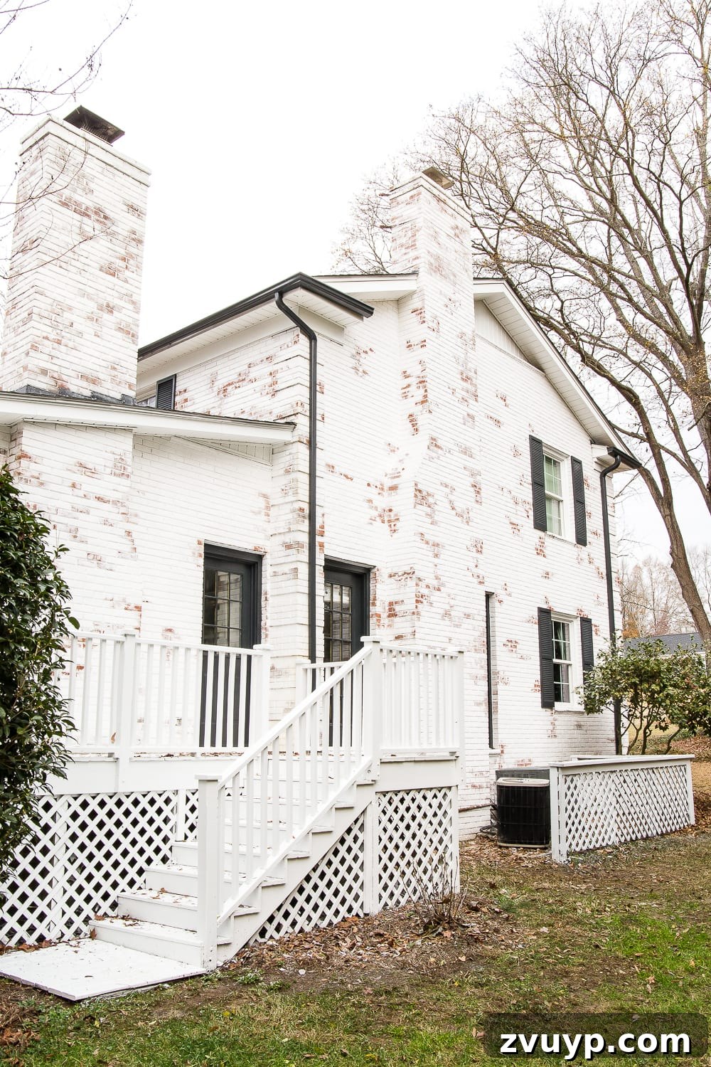 Limewash Magic: Our Brick Exterior Transformed 21 Romabio Bianco White limewash brick house makeover with black shutters and manicured landscaping