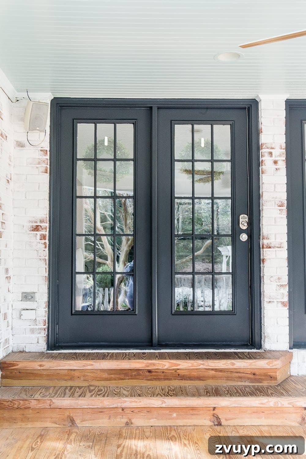Limewash Magic: Our Brick Exterior Transformed 29 Black French door on a back porch with a haint blue porch ceiling, a reflection of homeowner style