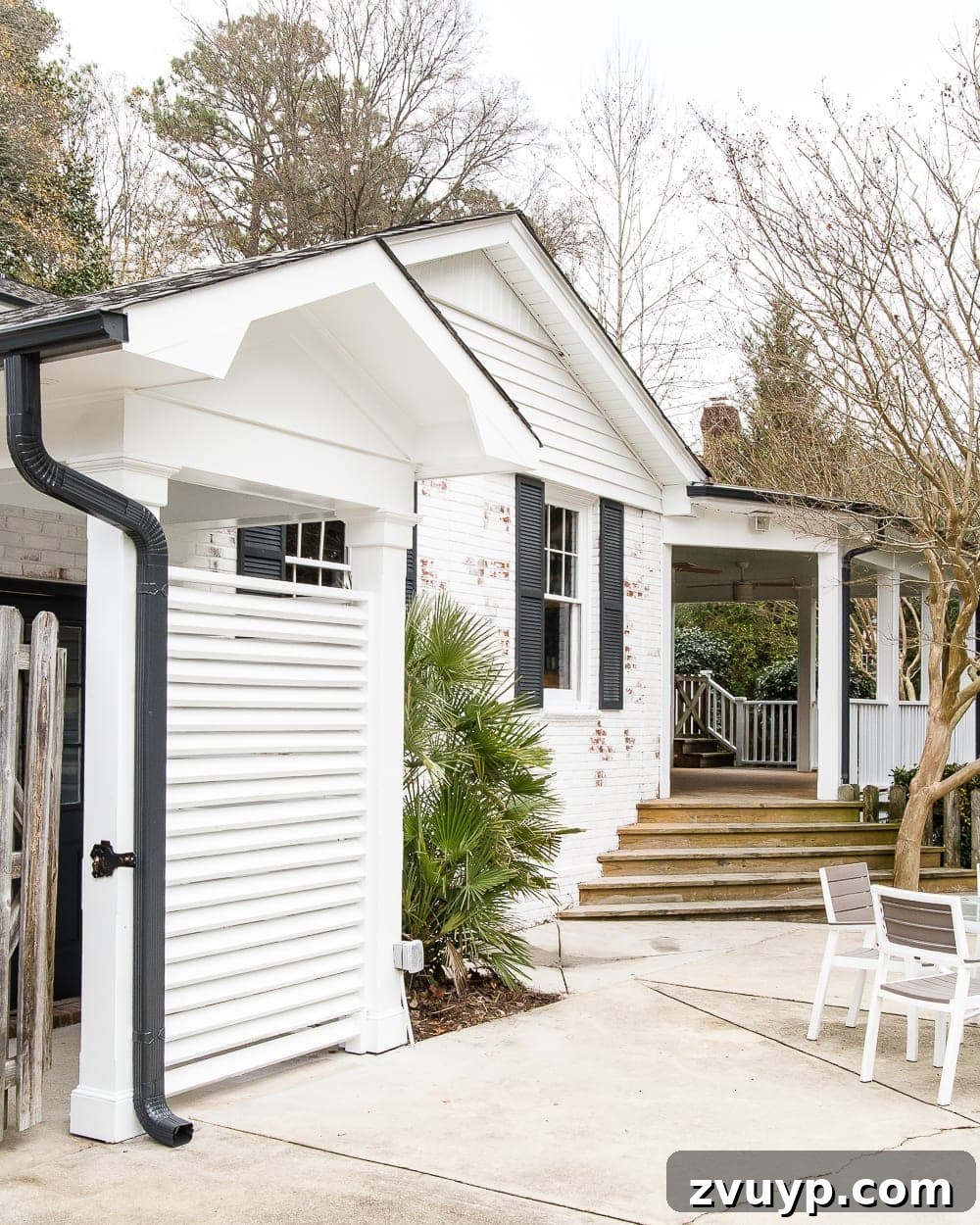 Limewash Magic: Our Brick Exterior Transformed 30 Back house exterior with white brick and black shutters, showcasing the completed limewash project