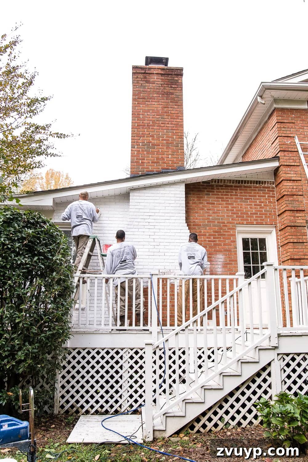 Limewash Magic: Our Brick Exterior Transformed 8 Limewash brick paint application on damp natural brick exterior
