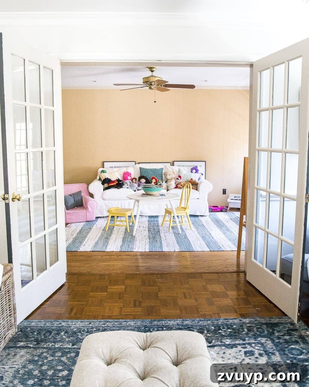 Kids Dream Playroom Revealed 2 Dated playroom before renovation, showing clutter and an old sofa, hinting at a future bright and organized kids' play space.