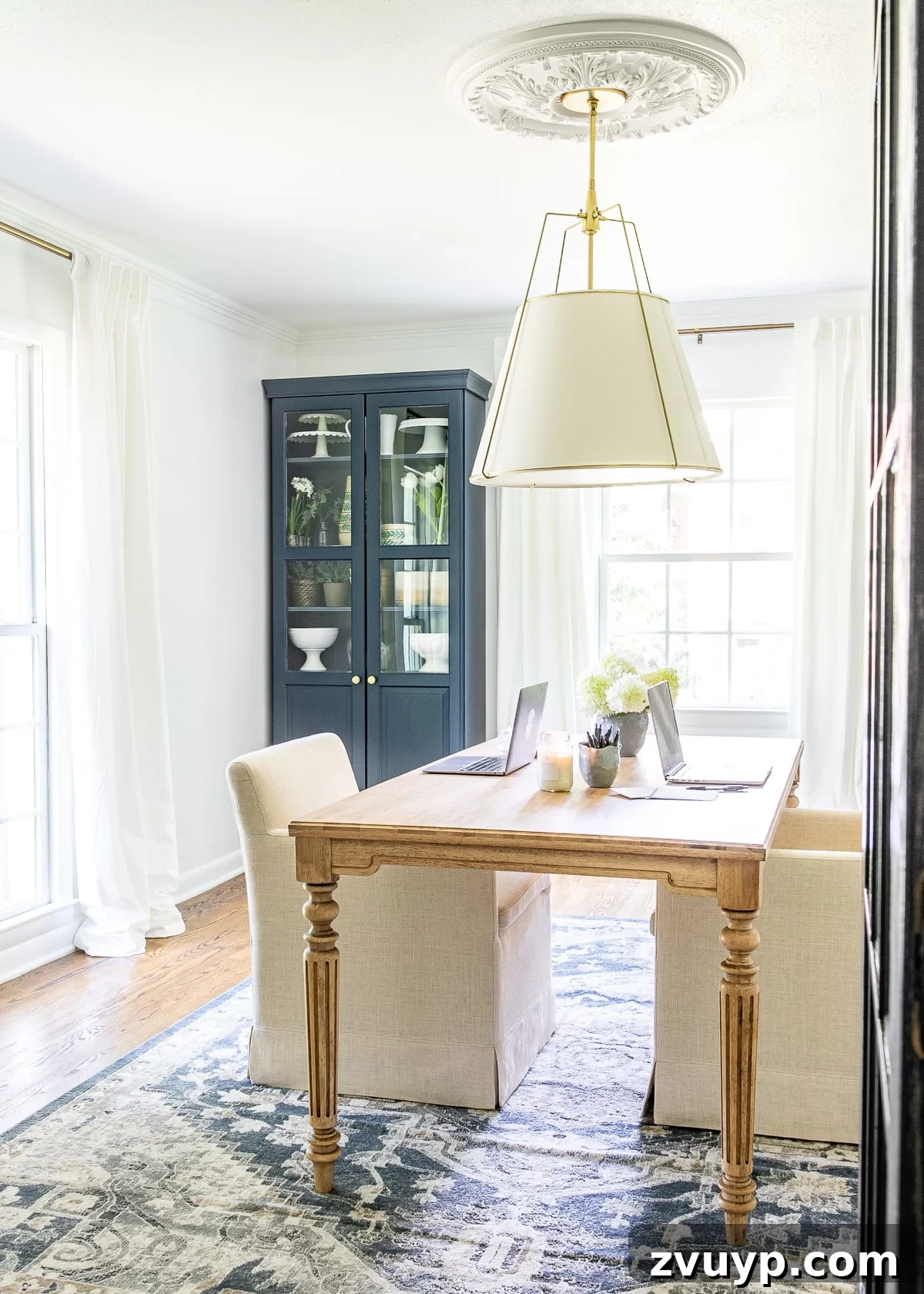 Ageless Interior Design: Lasting Style Principles 26 A stylish home office with navy blue cabinets, a sleek wood work table, and upholstered rolling chairs, reflecting a personalized and timeless design.