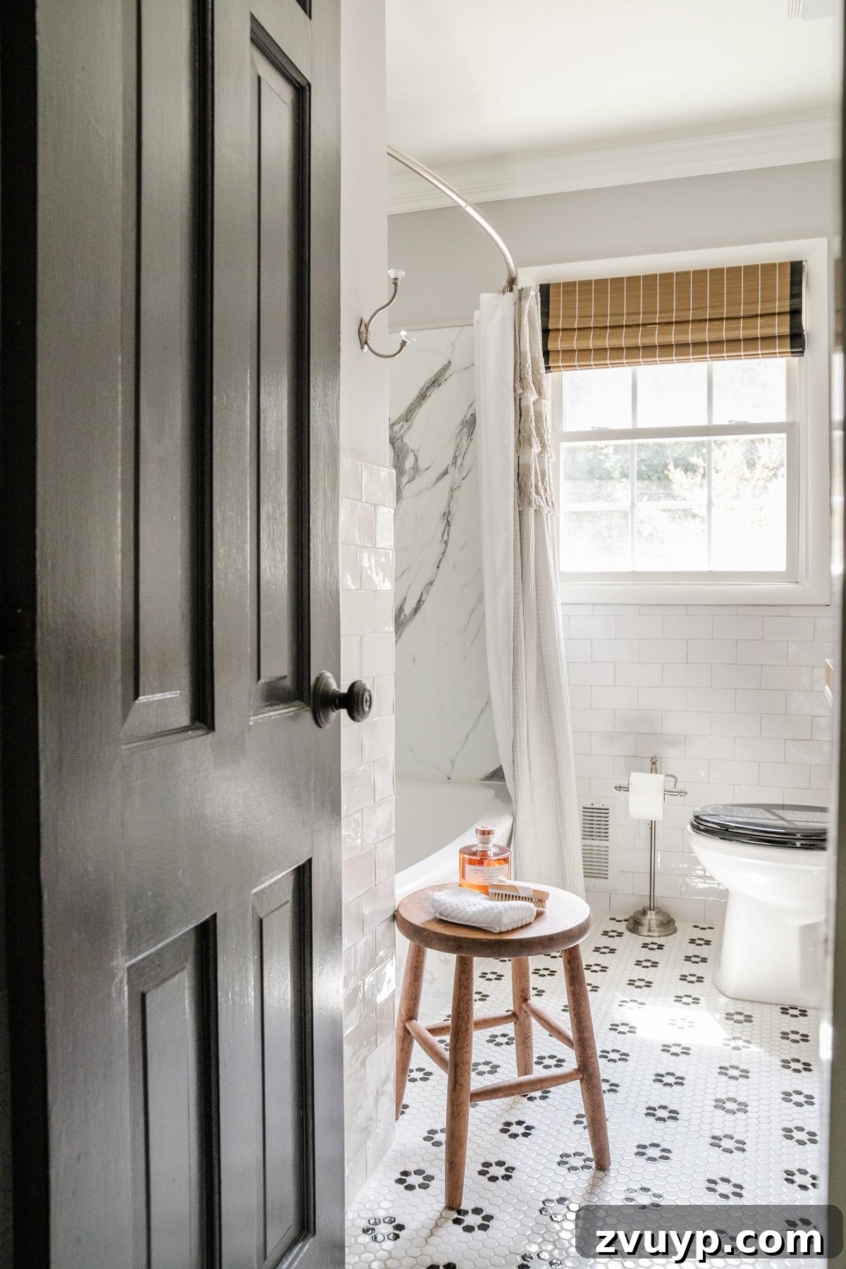 Ageless Interior Design: Lasting Style Principles 5 A classic black and white bathroom featuring subway tiles, a black door, and a retro-inspired tile floor, exuding timeless sophistication.