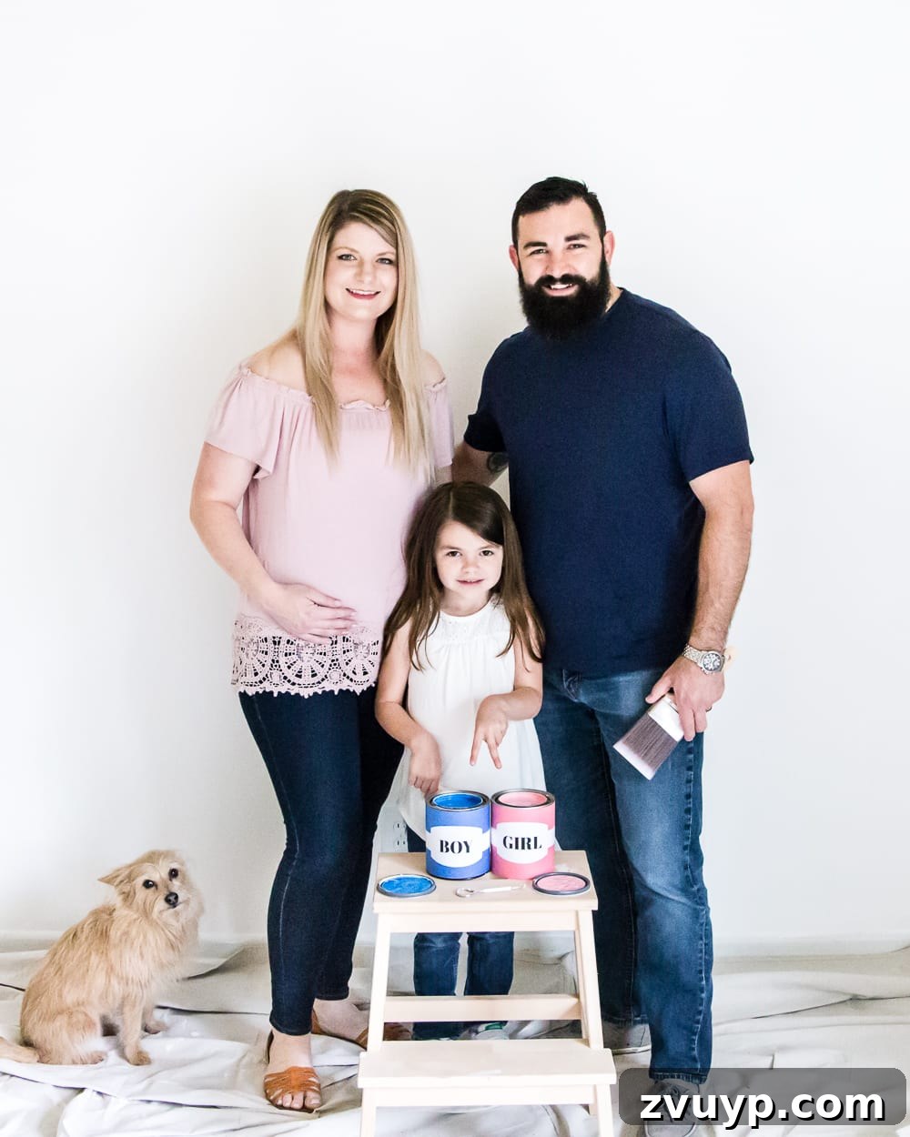 A gender reveal photo showing the expectant mother with a hint of paint on her cheek, building anticipation. #genderreveal #heorshe #boyorgirl #nursery #genderphotoshoot #DIYgenderreveal