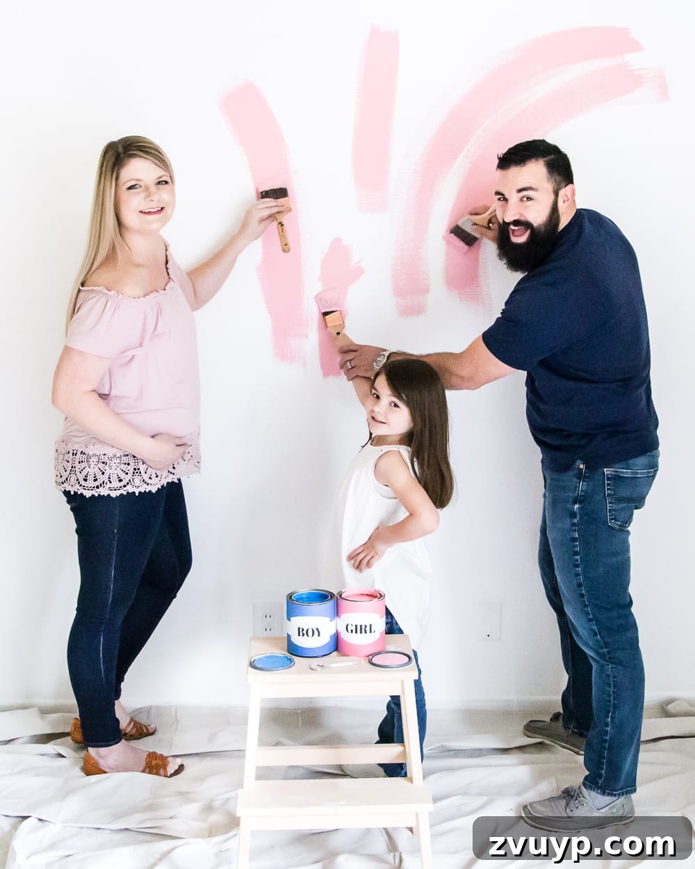 The expectant parents celebrating their baby girl gender reveal with pink paint, filled with joy in the nursery. #genderreveal #heorshe #boyorgirl #nursery #genderphotoshoot #DIYgenderreveal