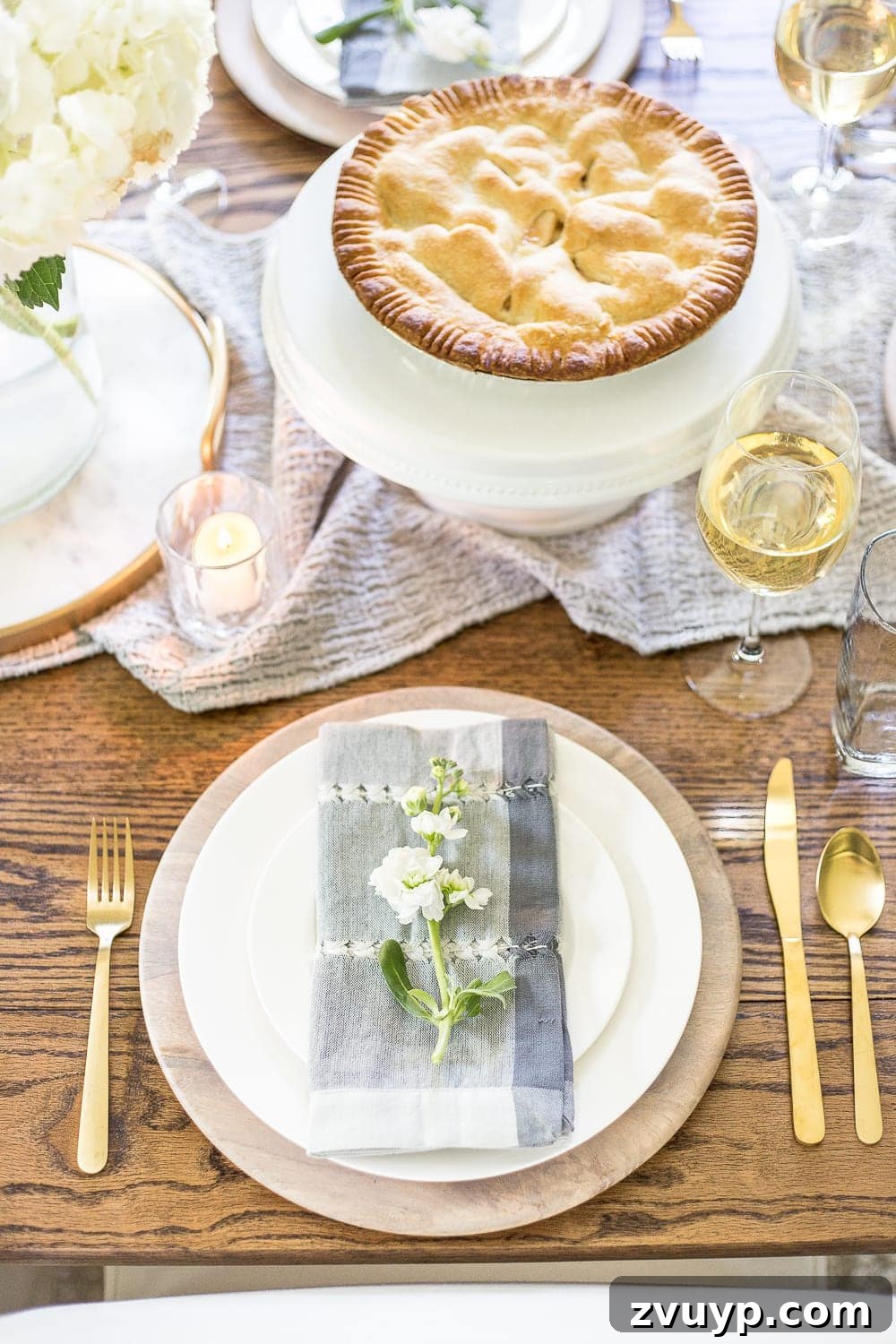 Close-up of elegant place setting with vintage-inspired dinnerware, crystal glasses, and a fresh floral accent, embodying timeless summer dining. #placesetting #elegantdinnerware #crystalglass #summerluxe #diningdetails #colonialhome 