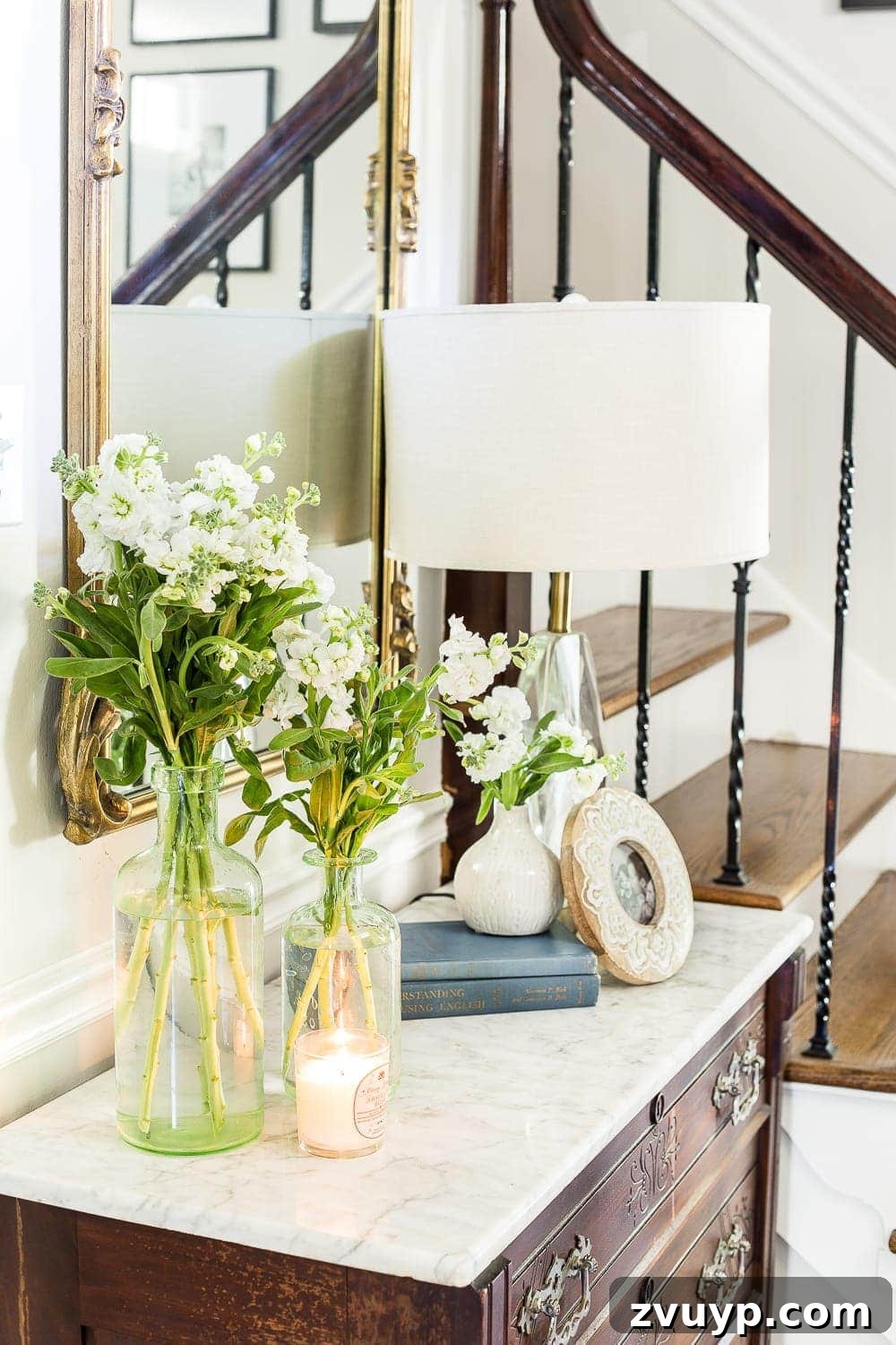 Inspiring Summer Homes 2018 5 Inviting foyer of a 1960 colonial home, featuring a vintage chest, elegant gallery wall, and light neutral colors for a timeless summer look. #foyerinspo #colonialdecor #vintagestyle #DIYhome #homeupgrade #summertour2018