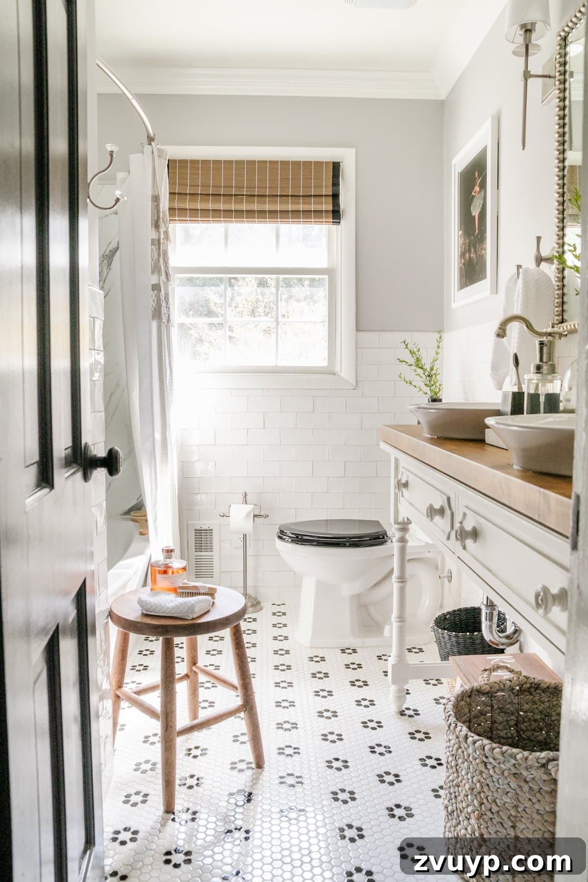 A small bathroom designed with glossy subway tile on the walls and complementary penny tile on the floor, effectively bouncing light to make the space appear larger.