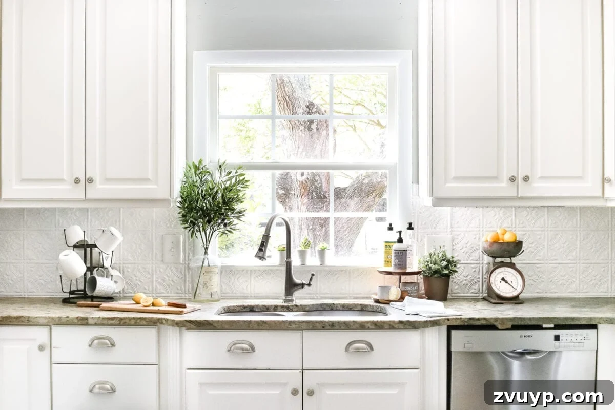 Cozy Cottagecore Kitchen Transformations That Won't Break the Bank 22 A view of the kitchen with white cabinets and the sink in front of the window, before the recent refresh, showing its original state.