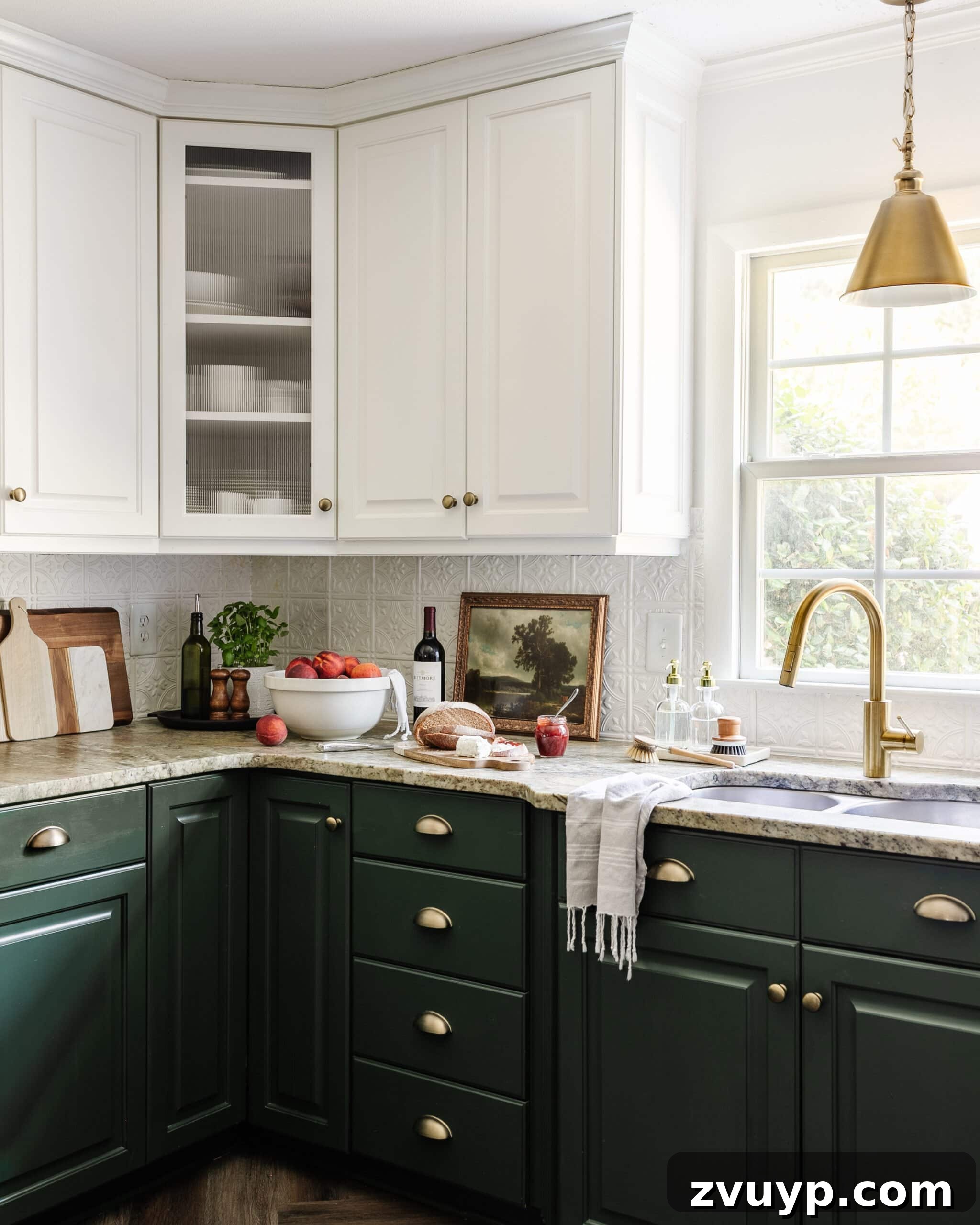 Cozy Cottagecore Kitchen Transformations That Won't Break the Bank 10 A leathered granite kitchen countertop styled with cottagecore decor, featuring a modern kitchen sink with a stylish brass faucet positioned in front of a window with ample natural light.