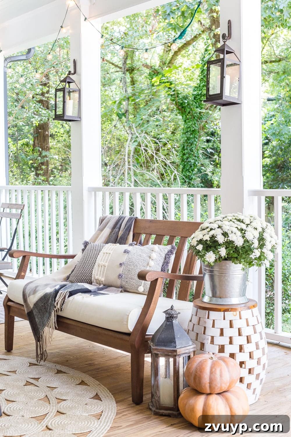 Autumn Porch Retreat: Crafting Cozy Outdoor Style 11 cozy fall porch with plaid throw blankets, textured pillows, pumpkins, lanterns, mums, and string lights