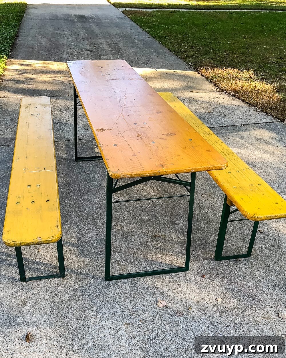 Before shot of the antique German beer garden table set with its original yellow stain and dark green peeling paint
