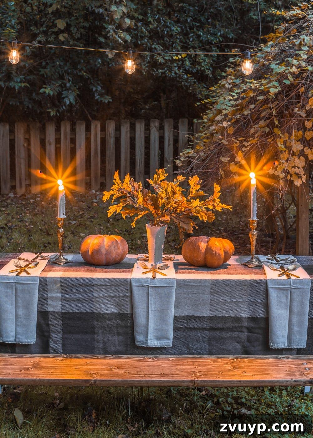Beautiful outdoor Thanksgiving table with string lights glowing, ready for guests