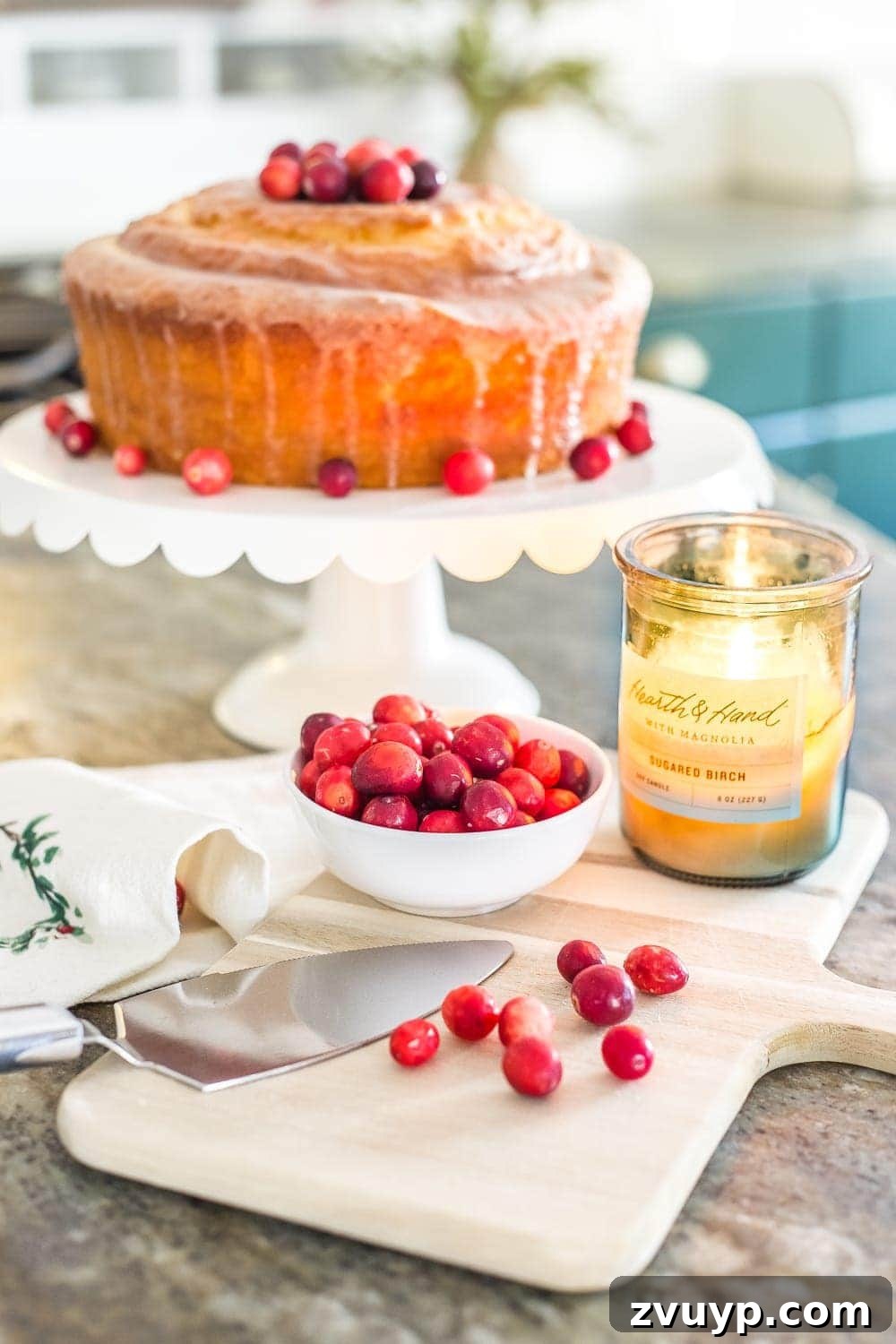 Festive Home Tours 2018 20 Kitchen island featuring a beautiful display of a bundt cake adorned with fresh cranberries and other festive decorations.