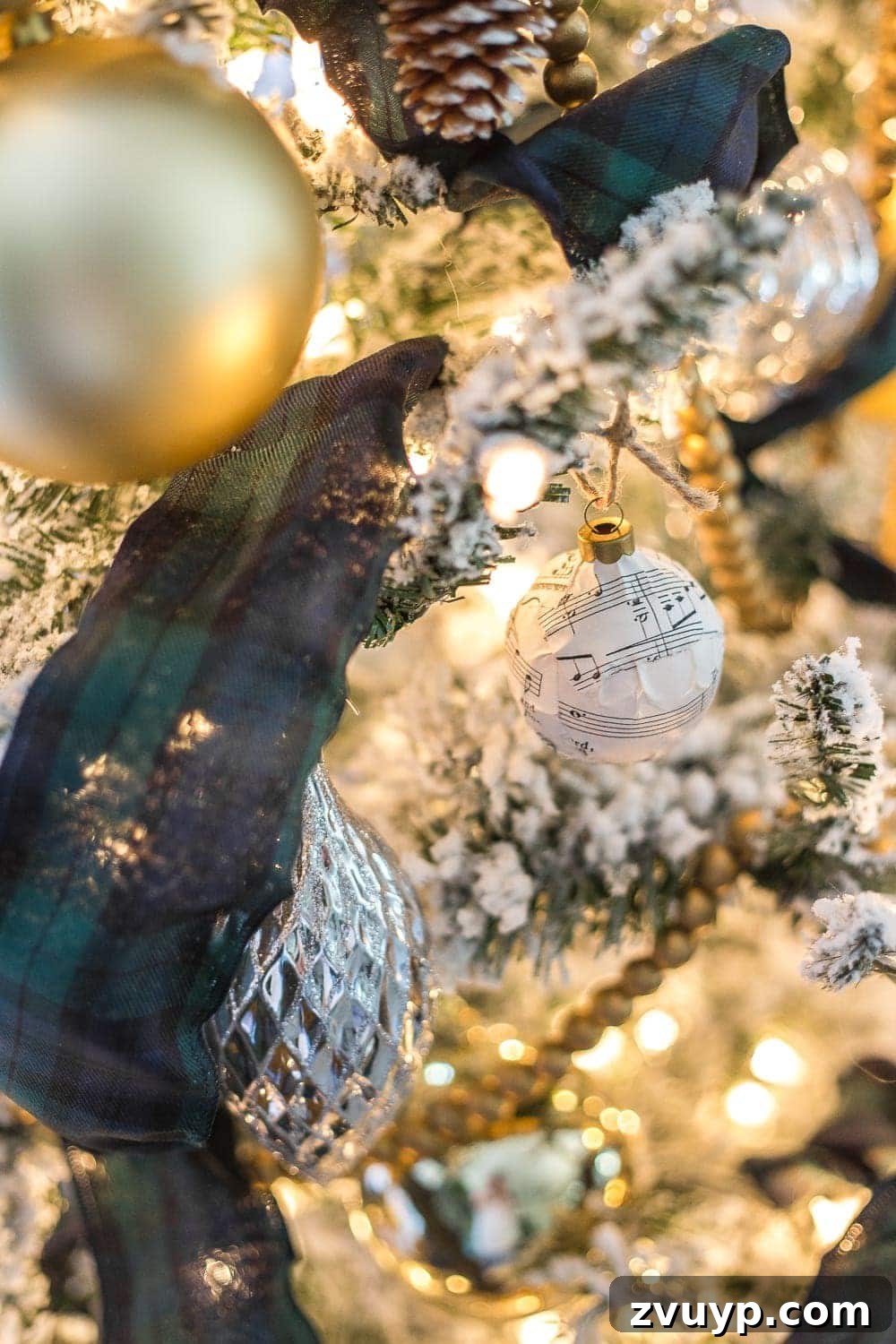 Festive Home Tours 2018 28 A vintage-inspired Christmas ornament, possibly DIY, made with sheet music decoupage, hanging on a decorated tree.