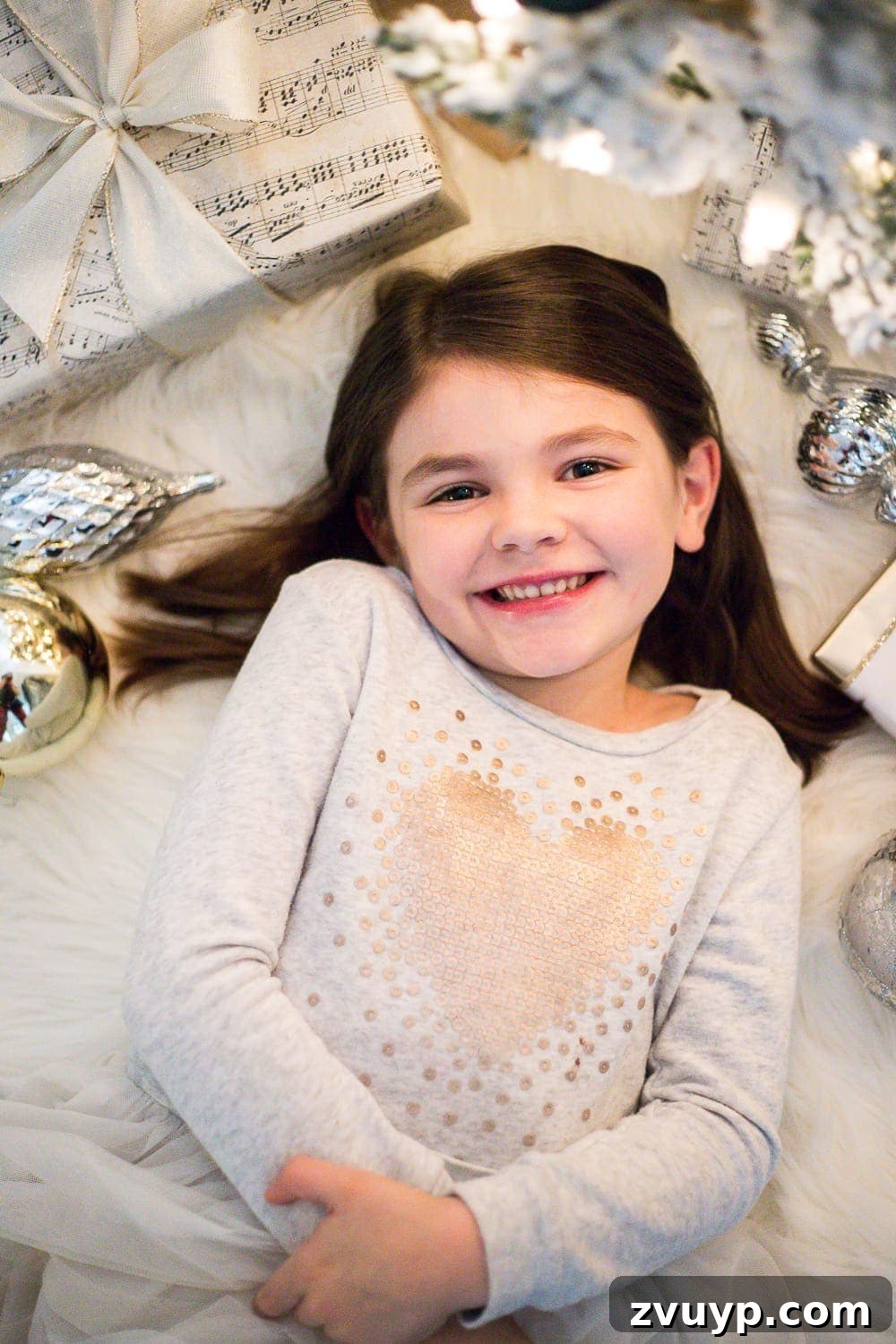 Cozy Christmas Captures: Easy DIY Family Photos at Home 8 Candid Christmas kids photos captured during a DIY photoshoot, featuring children interacting with festive props in natural lighting