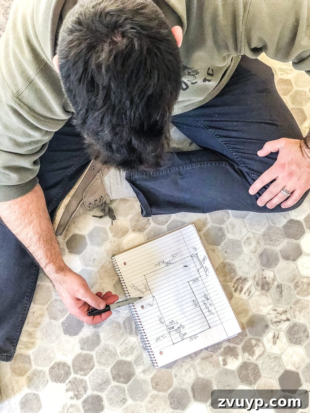 DIY Floor Makeover Seamless Sheet Vinyl Over Tile 12 A hand holding a pencil and paper with a room diagram and measurements, emphasizing the importance of accuracy.