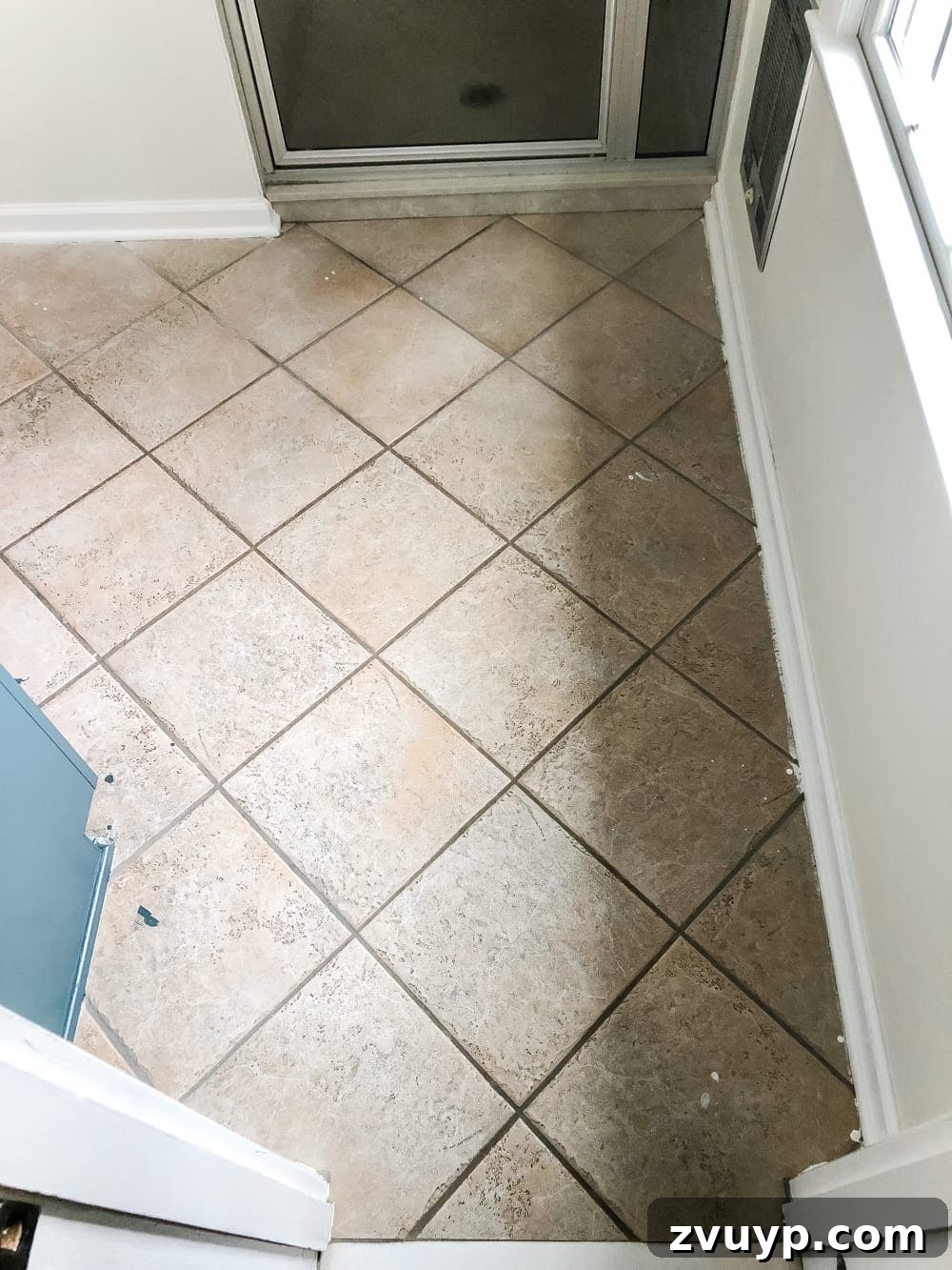 DIY Floor Makeover Seamless Sheet Vinyl Over Tile 3 Dated, worn old ceramic tile flooring before any renovation or vinyl installation.