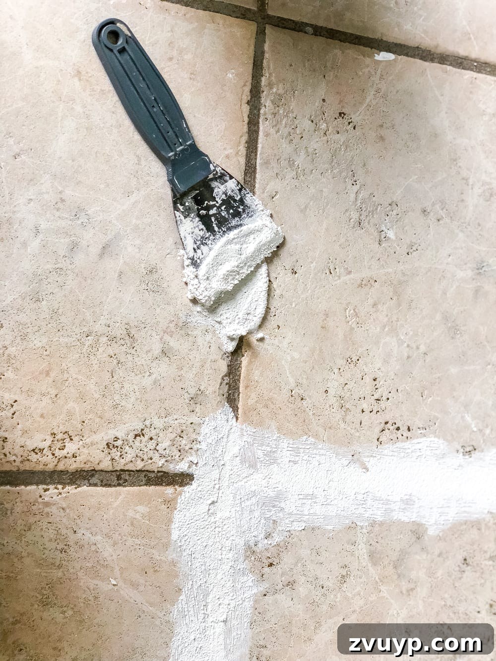 DIY Floor Makeover Seamless Sheet Vinyl Over Tile 7 Close-up view of thin-set mortar being applied smoothly over ceramic tile grout lines.