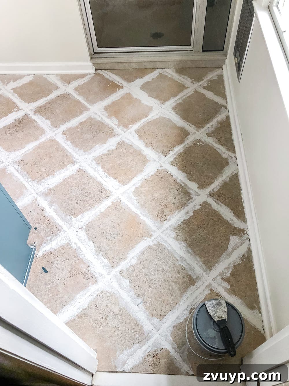 DIY Floor Makeover Seamless Sheet Vinyl Over Tile 8 Another perspective of a hand smoothing thin-set mortar over tile grout lines, focusing on even application.