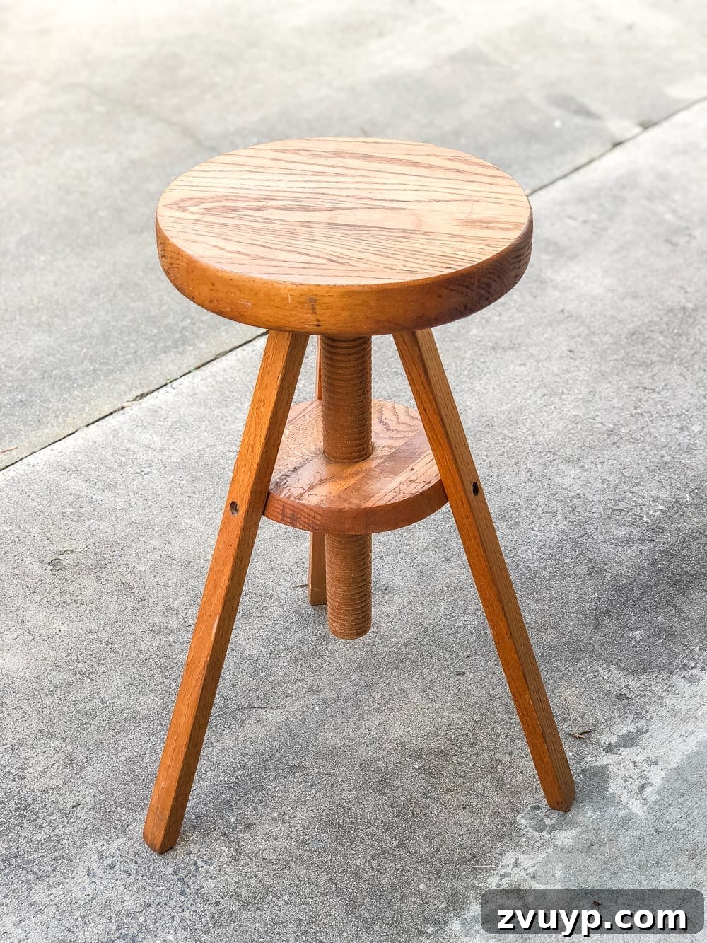 Beautifully transformed piano stool now serving as a global-inspired plant stand, featuring a white spray-painted finish and a delicate doily stencil pattern on top. Ideal for DIY home decor and thrift store flips.