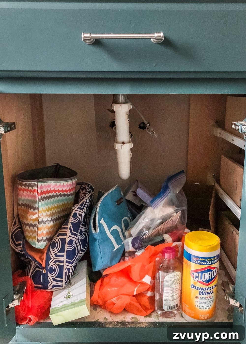From Mess to Marvel: 6 Steps to a Perfect Bathroom Vanity 4 Messy Bathroom Cabinet Interior Before Organization - An overhead shot revealing a jumbled and untidy bathroom cabinet with cleaning supplies and toiletries.