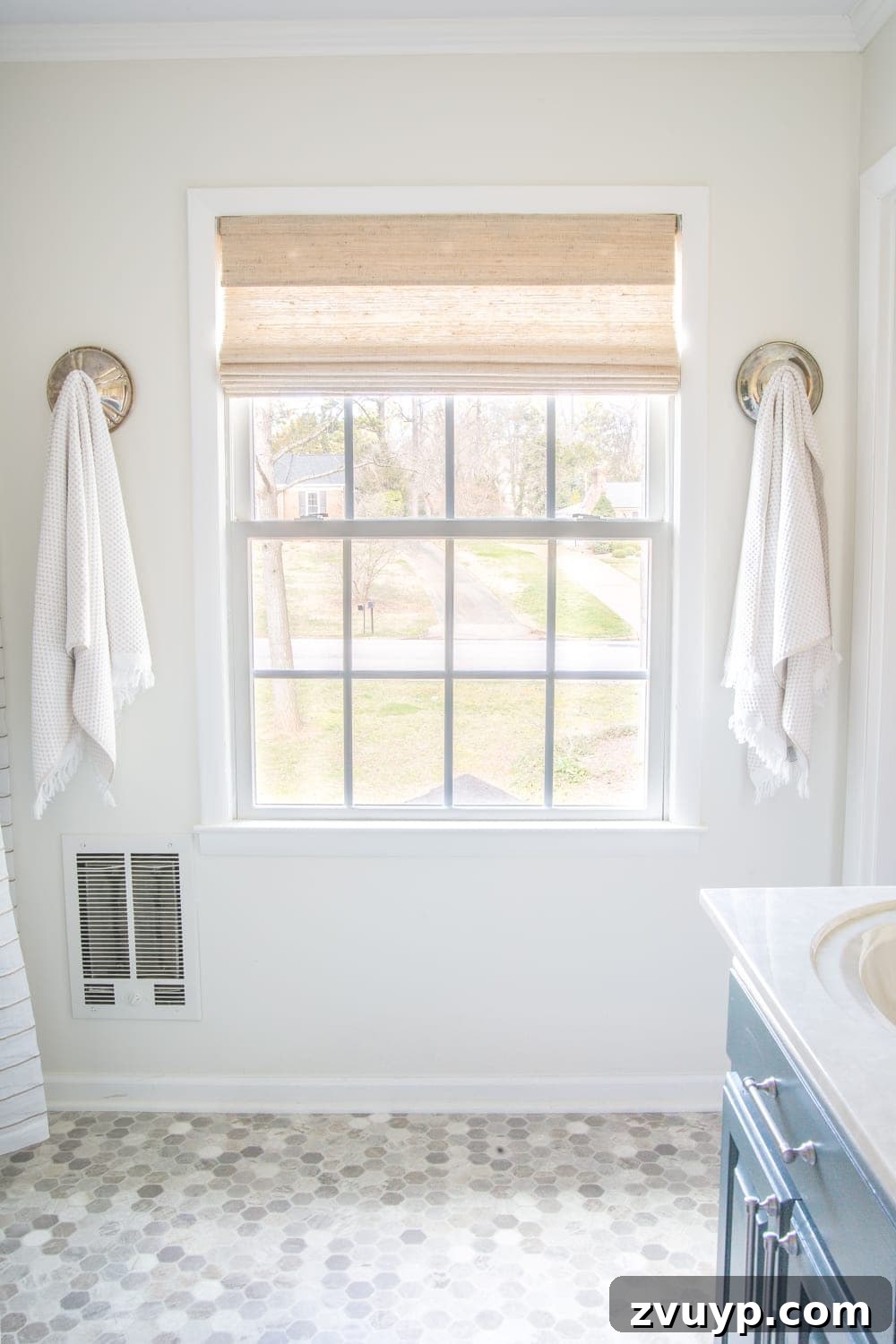 Budget Master Bath Glow-Up Unveiled 25 Budget Master Bathroom Refresh Reveal: Woven wood window shade in Bonaire Flaxen and hexagonal sheet vinyl flooring.