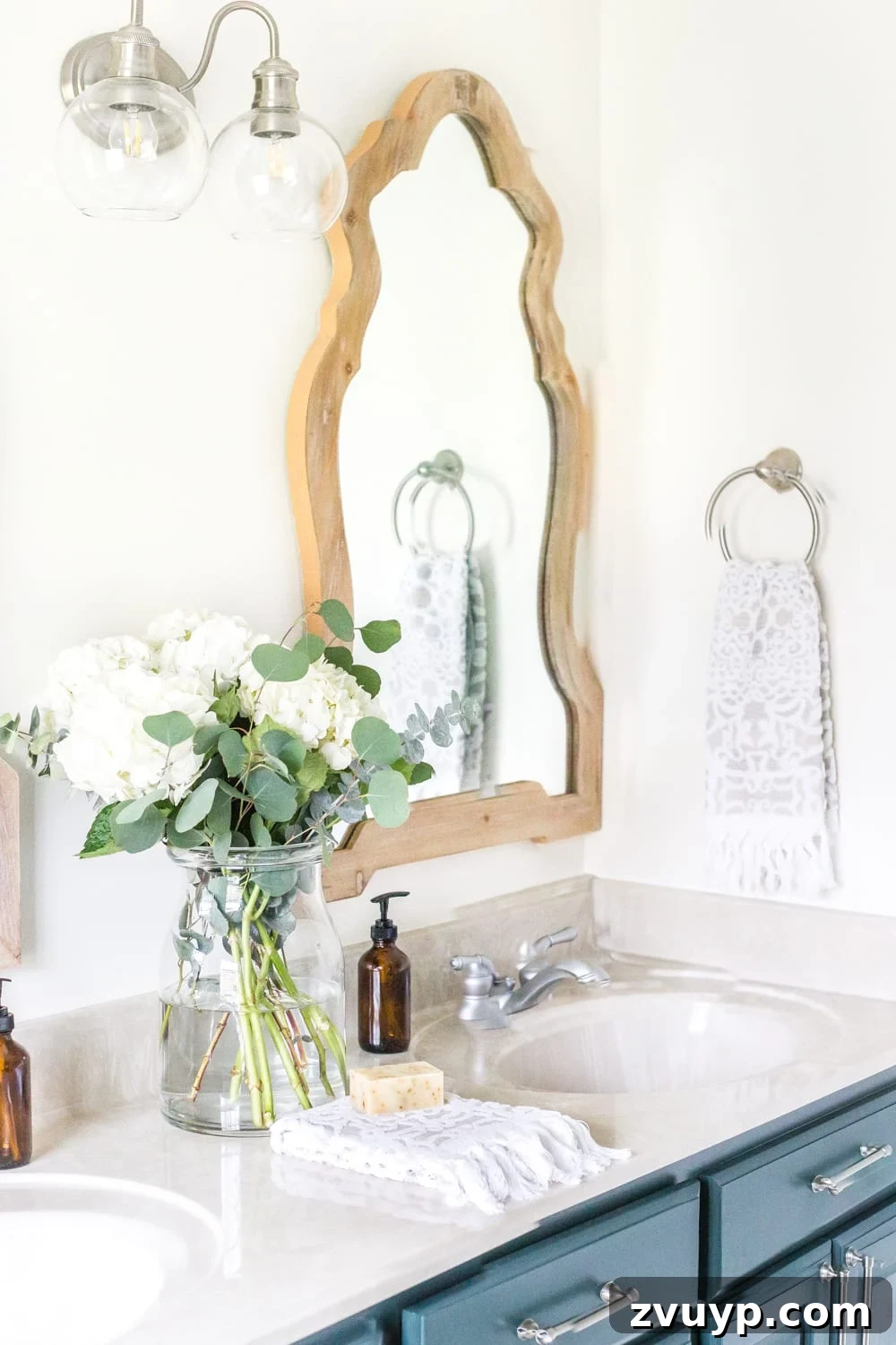 Budget Master Bath Glow-Up Unveiled 6 Budget Master Bathroom Refresh Reveal: Modern 2-light sconce and arched wooden mirrors enhance the vanity area.