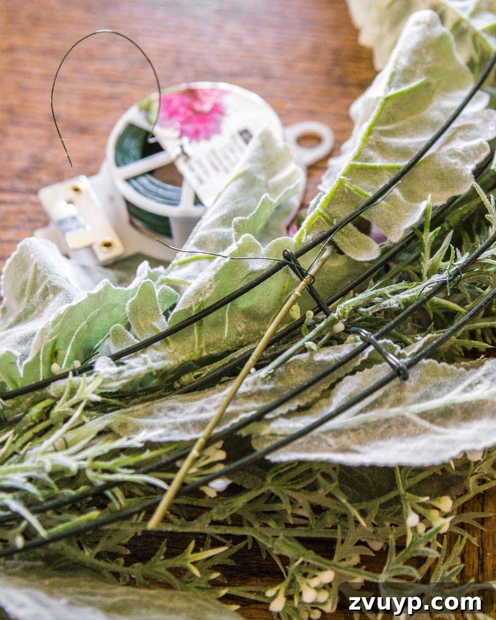 Handcrafted Sage and Blush Spring Wreath 7 DIY Sage and Blush Spring Wreath Tutorial | Step 3: Carefully placing and securing blush-toned artificial flowers to complete the romantic spring wreath design.