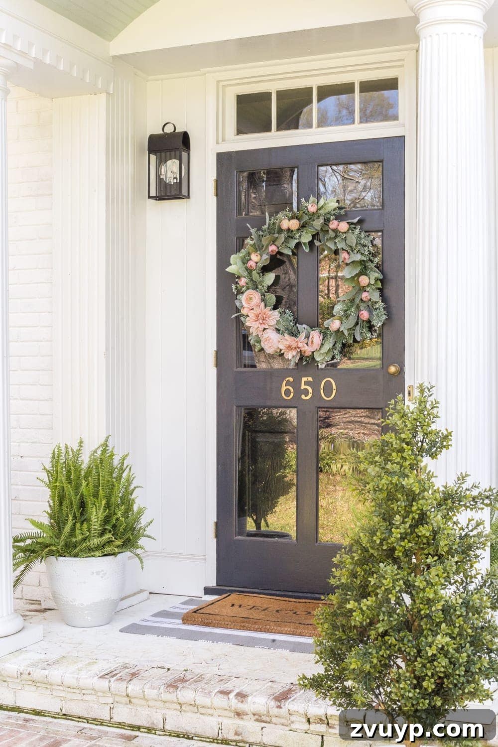 Simple Spring Porch Makeover Ideas 4 A cozy front porch adorned with spring decor, including potted plants and a decorative welcome mat.