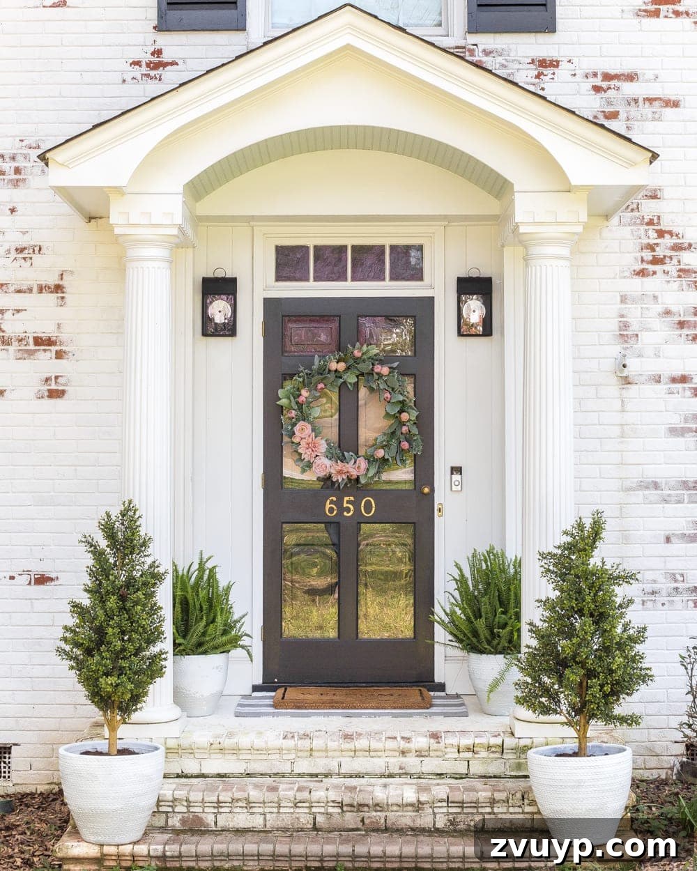 Simple Spring Porch Makeover Ideas 6 Two spray-painted planters with spring greenery flanking a front door, showcasing a budget-friendly decor idea.