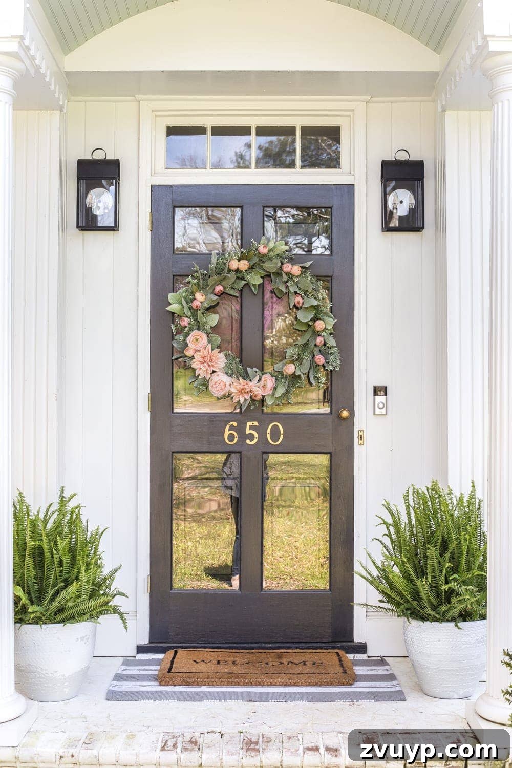 Simple Spring Porch Makeover Ideas 8 A clean, well-maintained white limewashed porch with potted plants and a subtle layered rug, ready for spring visitors.