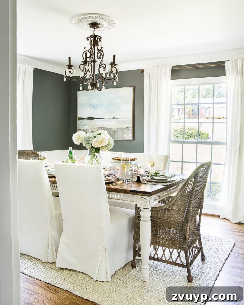 Our Home's Two Year Evolution A Before and After Tour 10 After shot of our dining room, featuring a large farmhouse table, modern chairs, and a striking chandelier, creating an elegant yet relaxed space.
