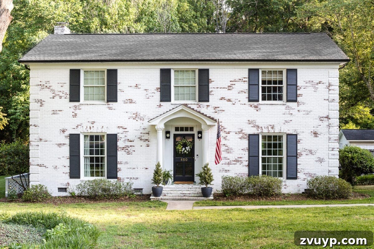 Our Home's Two Year Evolution A Before and After Tour 4 After shot of our home's limewashed brick exterior, featuring a charming summer porch with string lights, enhancing its modern farmhouse appeal.