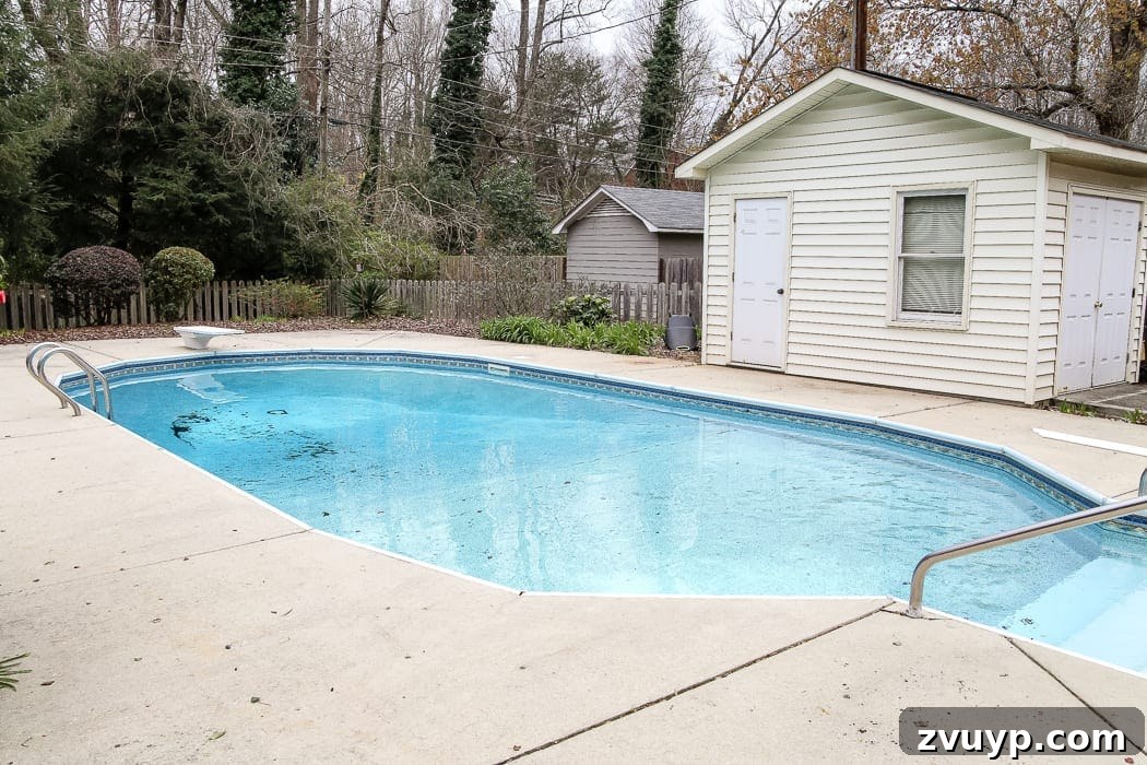 Our Home's Two Year Evolution A Before and After Tour 72 Before shot of the pool area, showing an older pool and beige pool shed surrounded by overgrown landscaping.