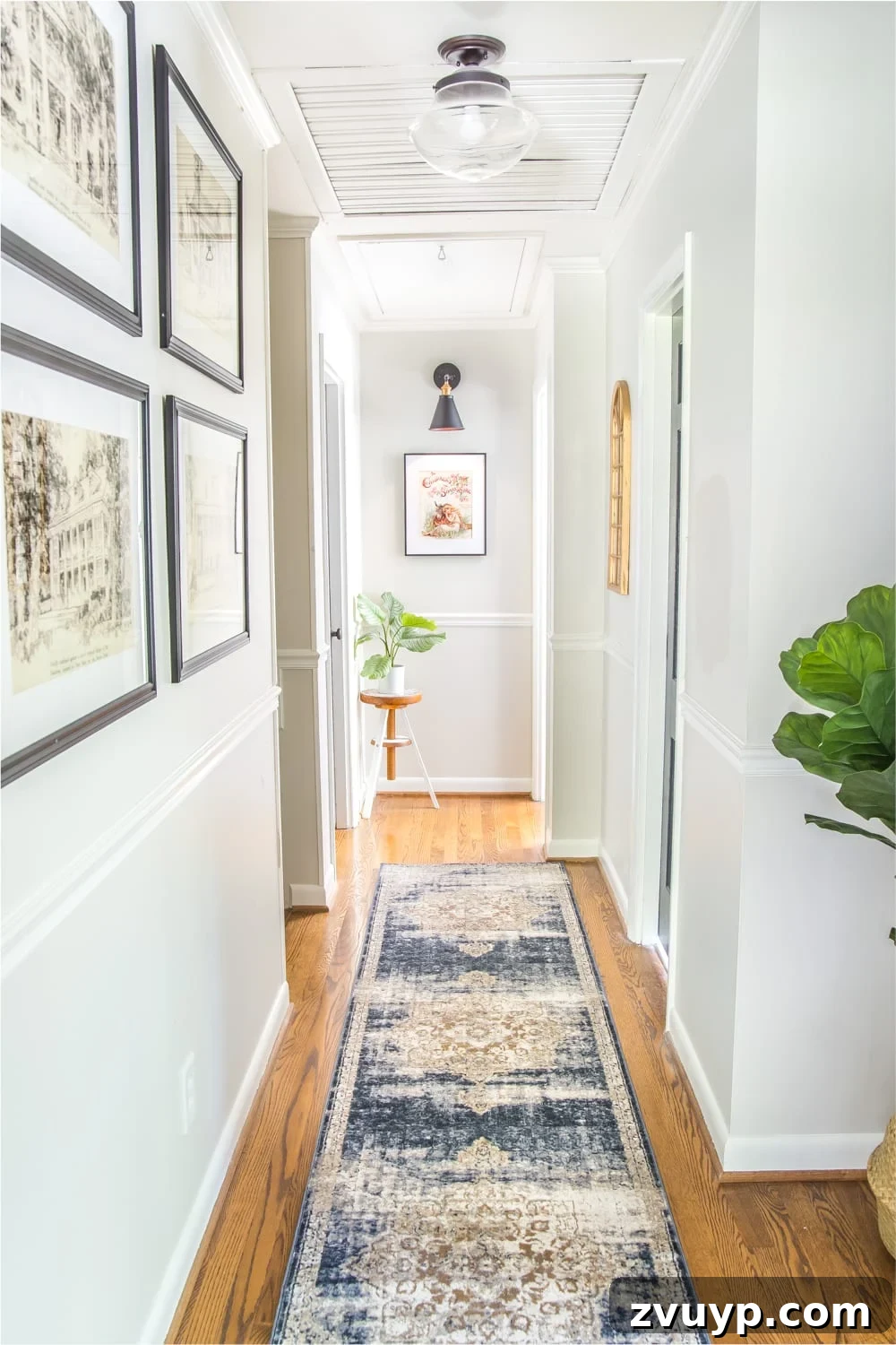 Stylish Solutions for Skinny Hallways 4 hallway decor ideas - light gray painted walls in narrow hallway with runner, wall decor, and plants