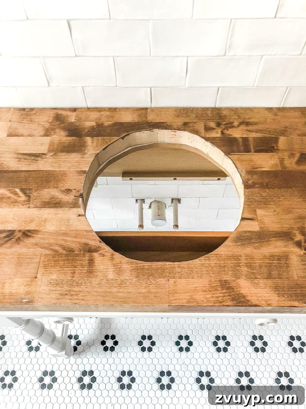 Upgrade Your Console Table to a Stunning Bathroom Vanity 13 Applying stain and Spar Urethane to a butcher block countertop for a DIY bathroom vanity, ensuring waterproofing.