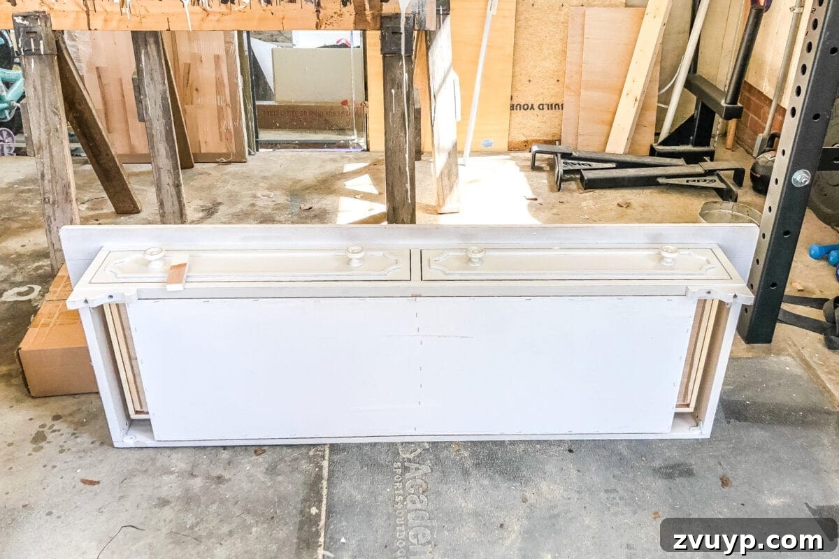 Upgrade Your Console Table to a Stunning Bathroom Vanity 4 Robert working on converting a console table into a bathroom vanity in a garage workshop.