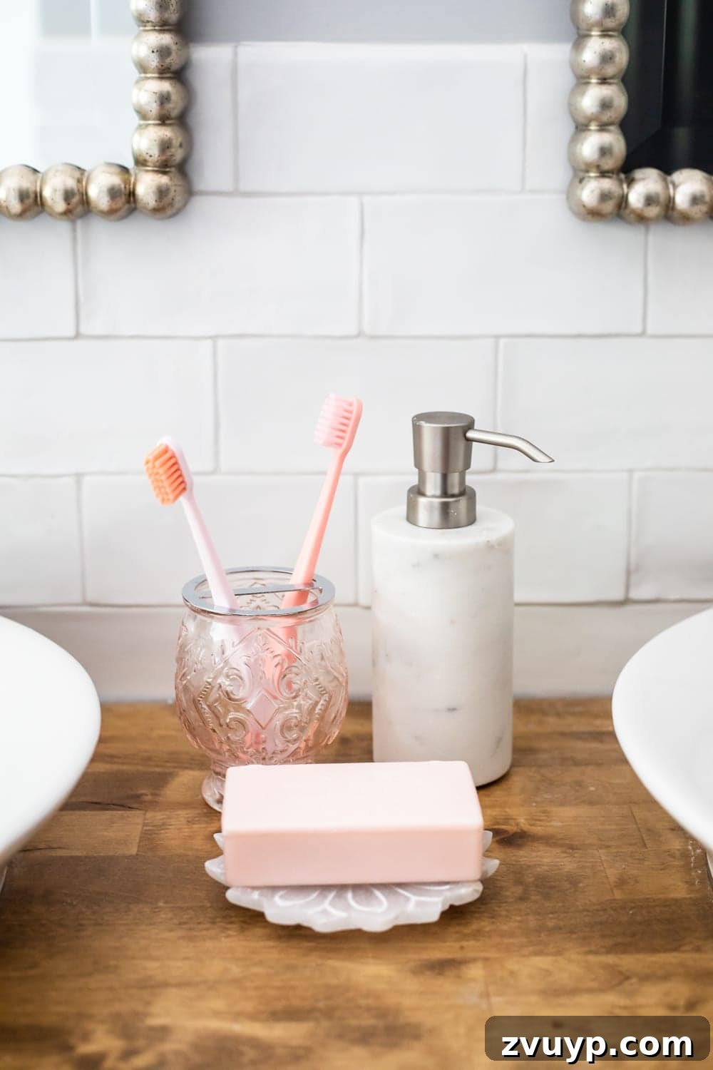Stylish Bathroom Accessories: Blush toothbrush holder, marble soap dispenser, and lotus soap dish on a butcher block countertop