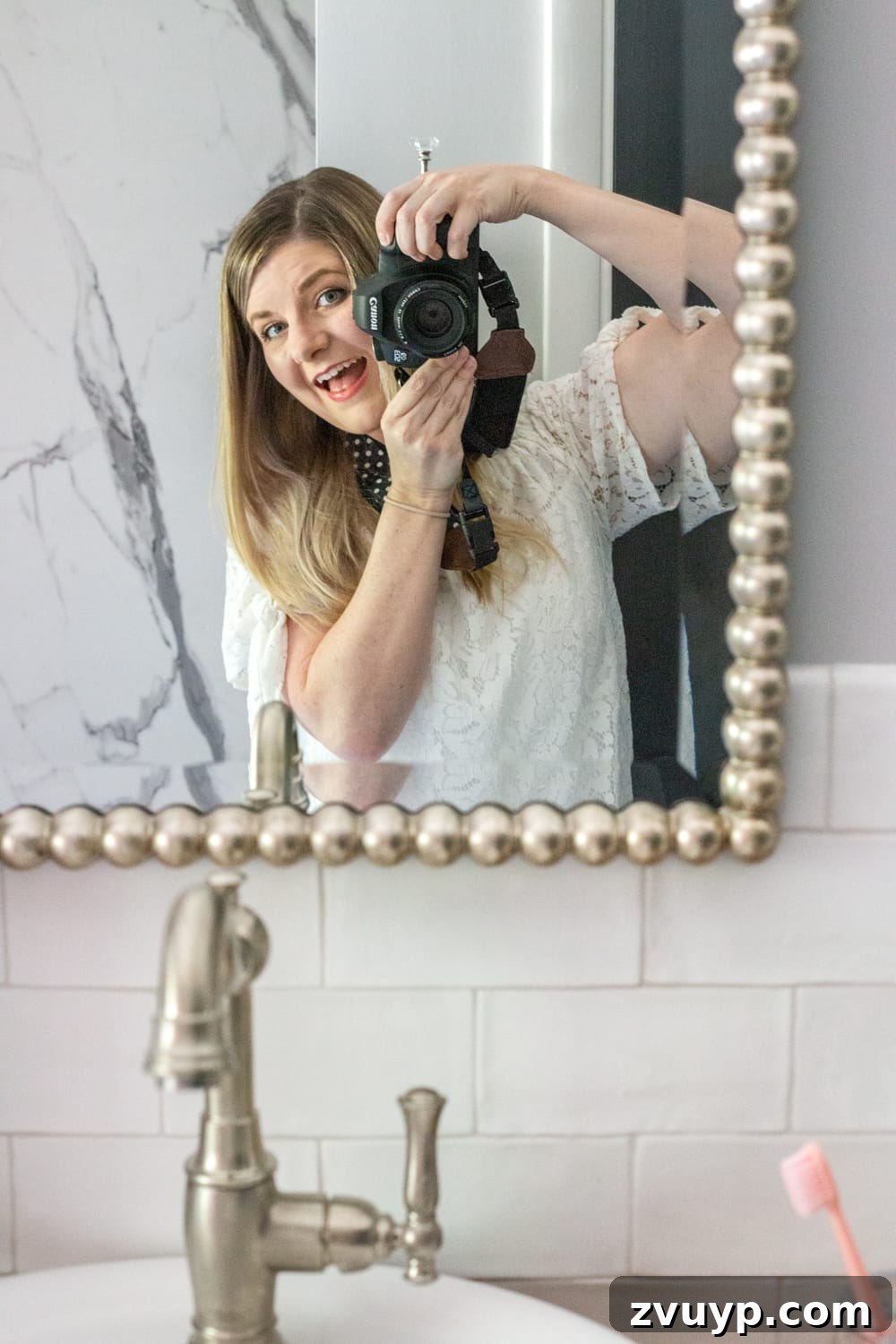 Proud designer takes a mirror selfie in her newly renovated girly and classic kids' bathroom