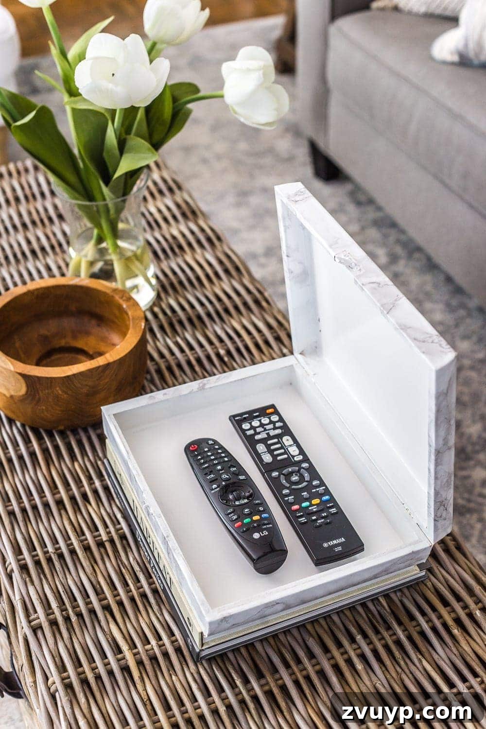 Cigar Box to Chic Faux Marble Remote Organizer 9 Marble contact paper remote control holder on a coffee table with other decor items, showcasing its integration into the living space.