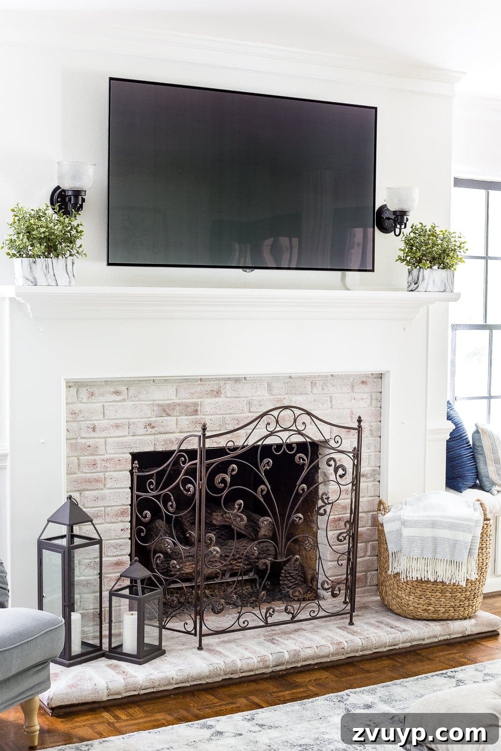 Beyond the Screen: Creative Ways to Style Your TV Area 2 Before: A summer living room with a busy mantel and visible TV setup.