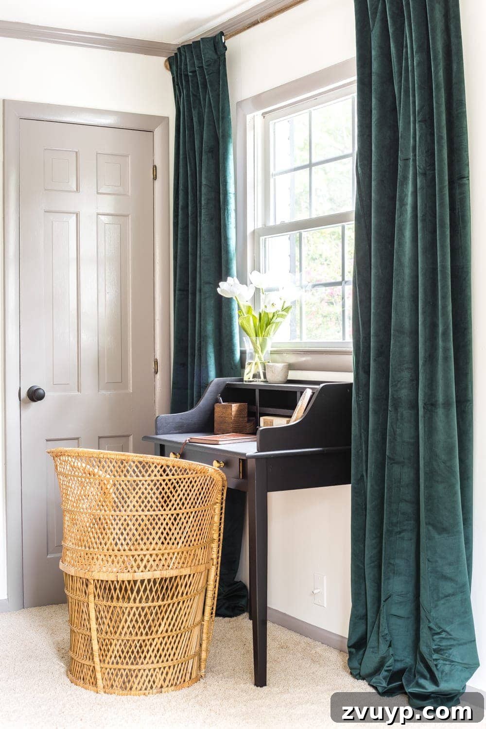 Giving an Old Writing Desk a New Story 6 Guest bedroom corner featuring the black vintage desk, rattan chair, and green velvet curtains