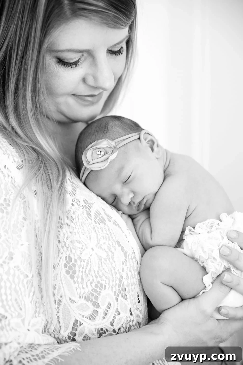 The Fog of Motherhood My PPD Story 2 Mother holding newborn baby Regan, a tender moment captured in a professional photo, representing the journey of early motherhood and postpartum challenges.