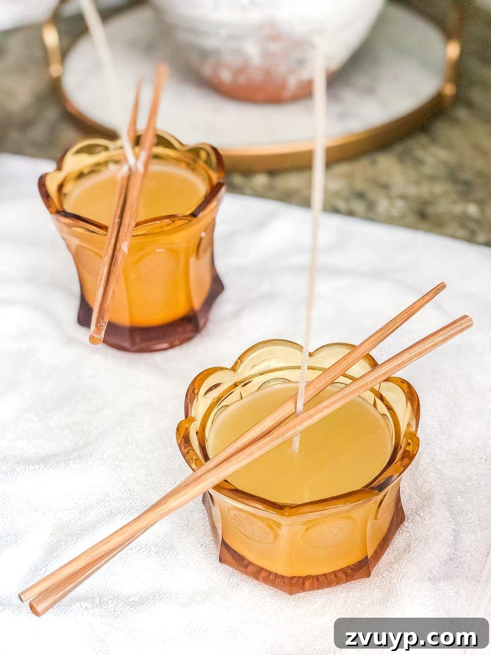 Sweet Dish Glow: DIY Candle Making 6 DIY candle wicks held upright with chopsticks while soy wax cools and hardens.