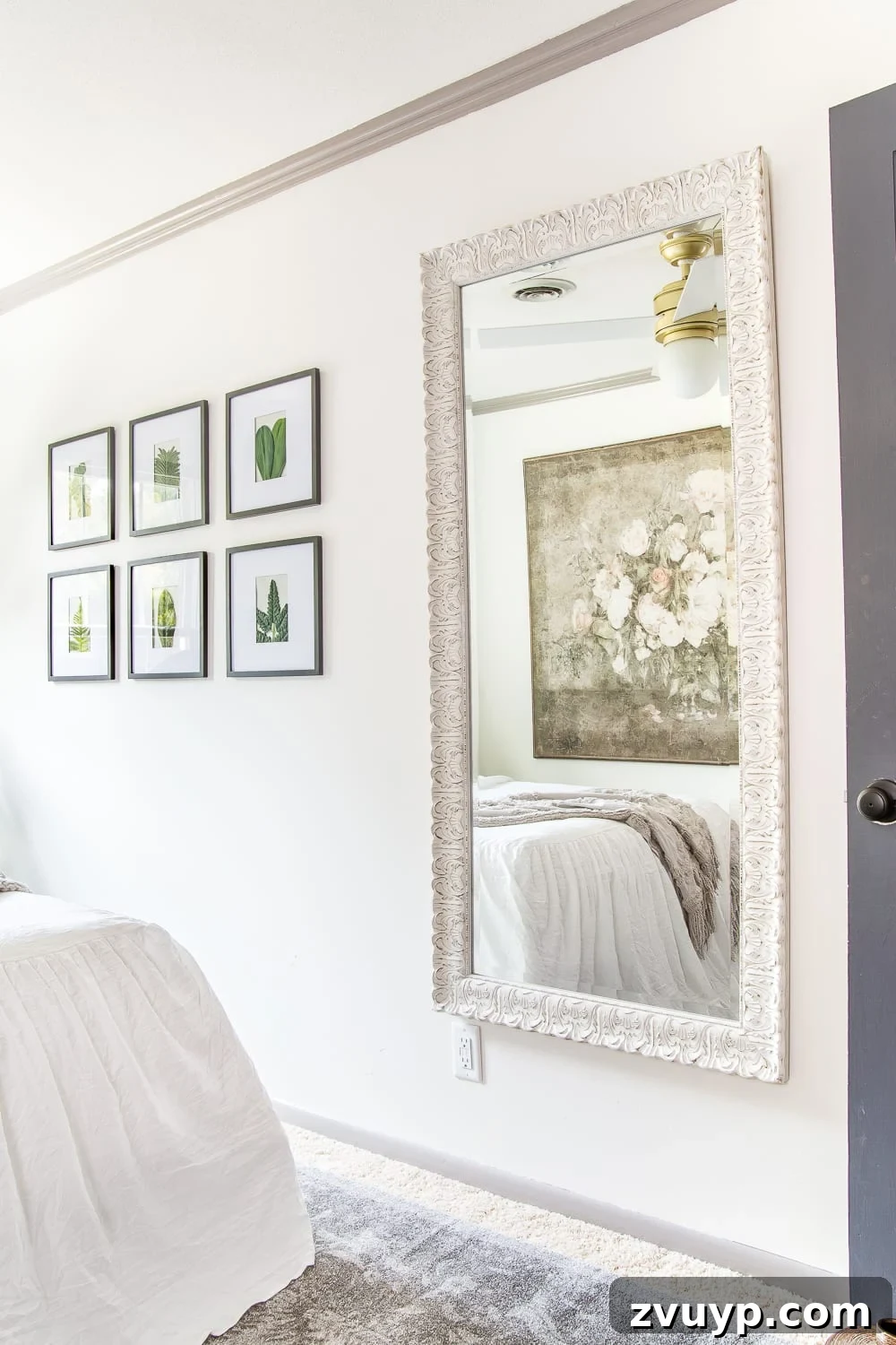 A boring guest bedroom gets a luxe, vintage chic makeover using thrifty projects, budget finds, and simple decorating tricks to maximize style and space. Full-length mirror reflecting light and adding depth to the guest bedroom.