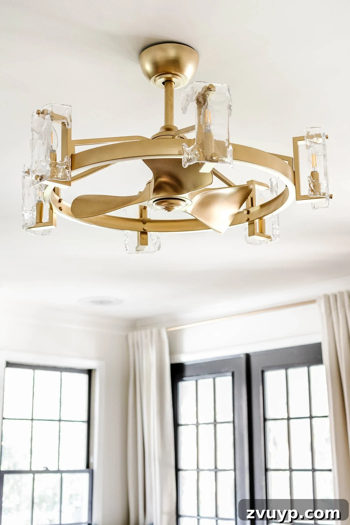 20 Handpicked Modern Ceiling Fans to Adorn Your Home 5 Elegant gold chandelier ceiling fan that combines opulent lighting with practical air movement for a chic living space.