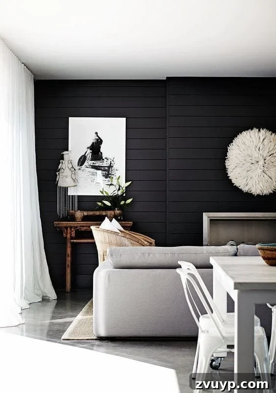 Black Paint: A Bold Design Statement 20 Cozy black living room with a large sectional sofa and textured rug