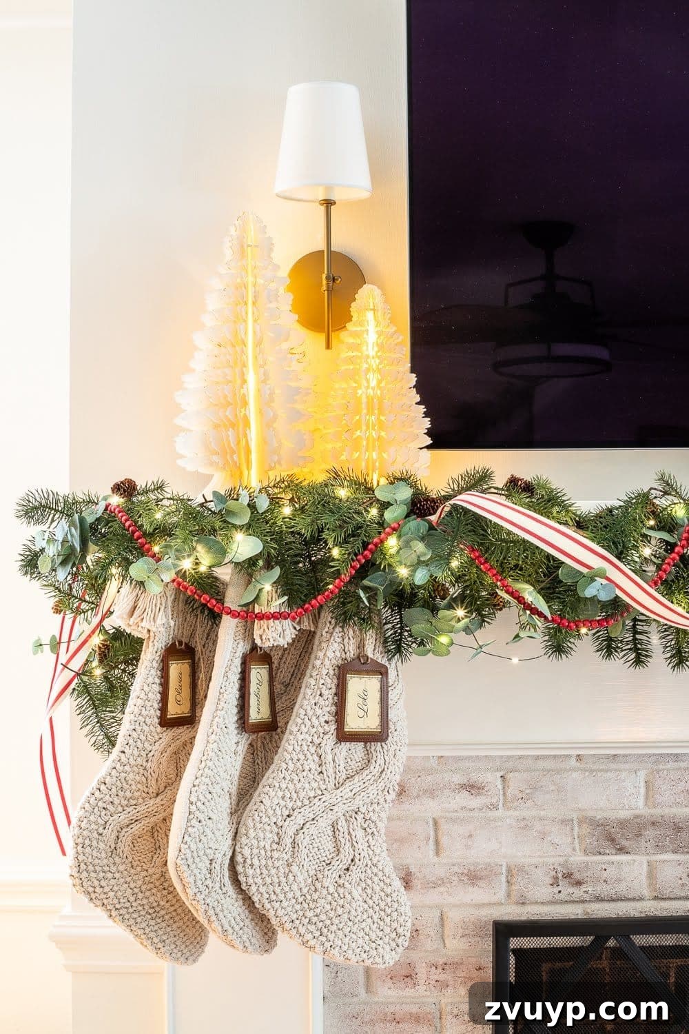 Weaving Past and Present: A Swedish Christmas Decor Story 20 A festive Swedish Christmas scene with enchanting paper tree figurines, cozy chunky knit stockings, abundant greenery, warm fairy lights, and cheerful pops of red, creating a harmonious and inviting holiday display.