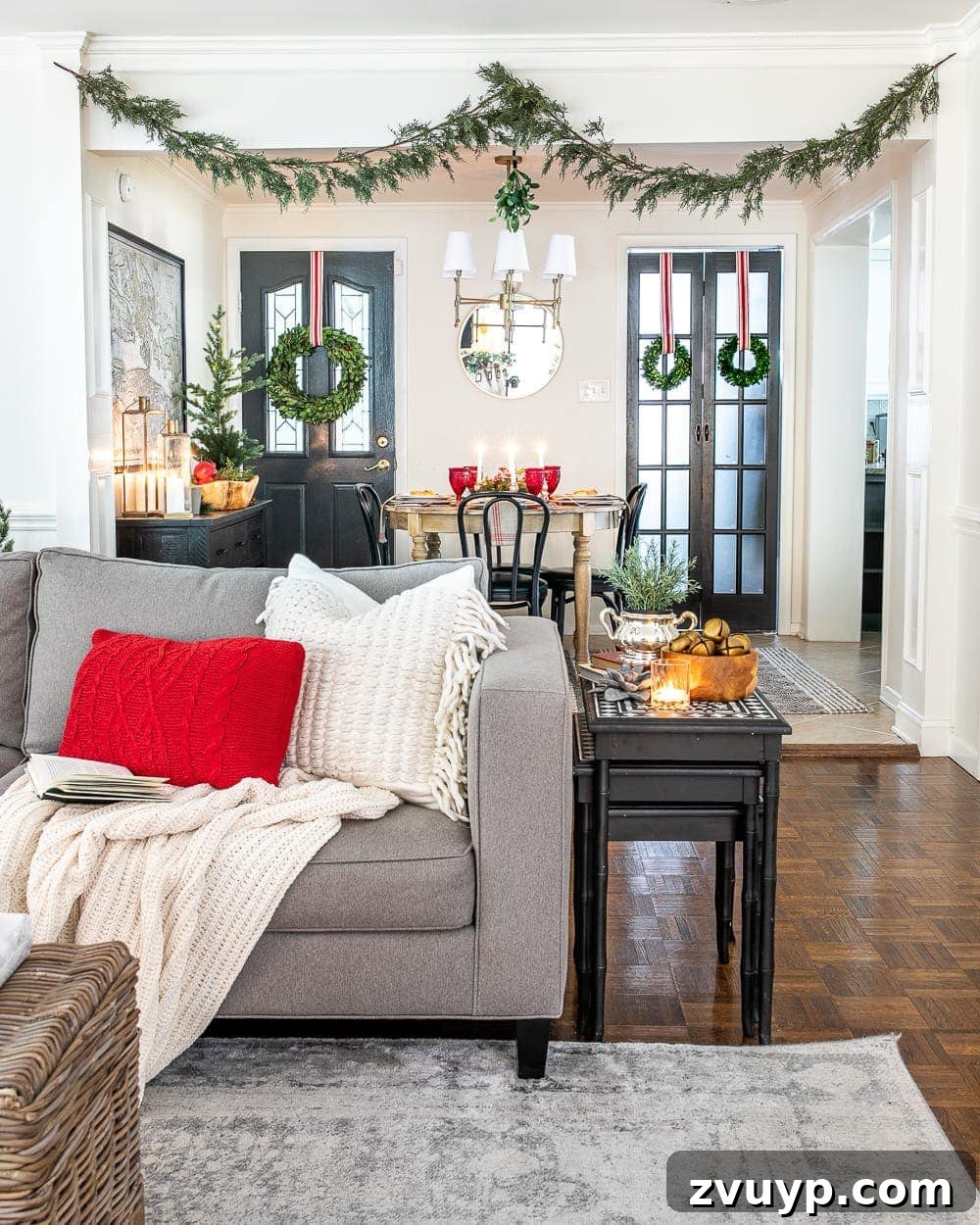 Festive Home Tour 20 Christmas decor ideas: A seamless view of a cozy Christmas living room blending with a festive breakfast nook, featuring realistic faux garland and mistletoe, creating a harmonious holiday ambiance.